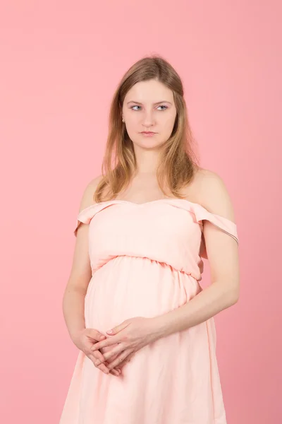 Gravid kvinna på en rosa bakgrund — Stockfoto