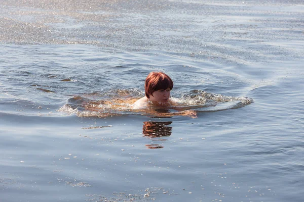 Vrouw zwemmen in koud bronwater — Stockfoto