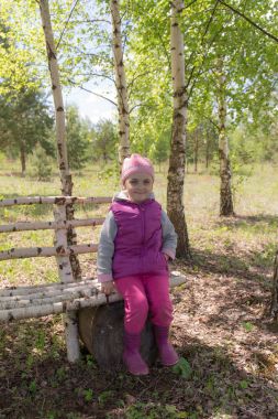 Kız bir bankta oturan