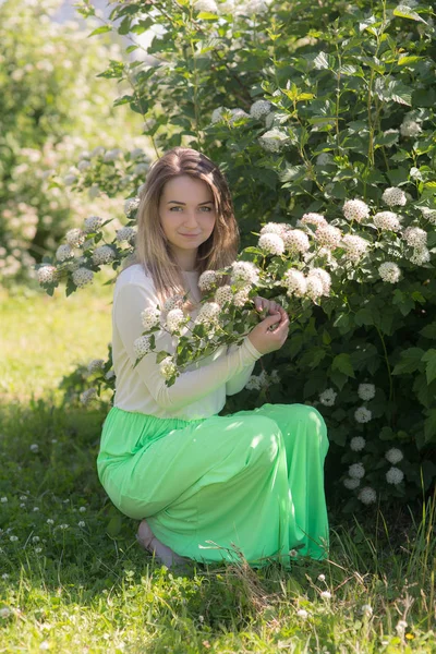 Ragazza vicino a un cespuglio fiorito — Foto Stock