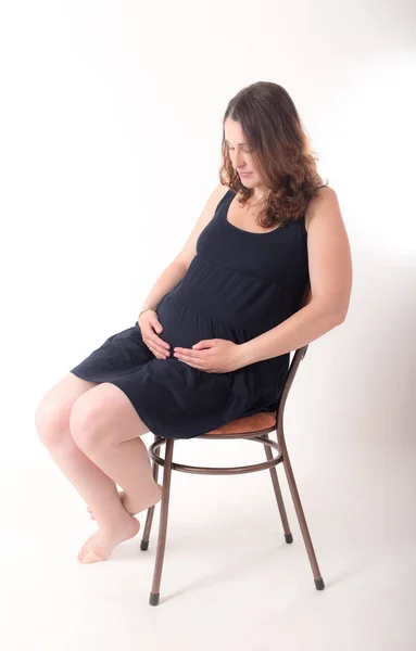 Terhes nő egy székre — Stock Fotó