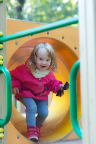 Chica en movimiento en un parque infantil — Foto de Stock