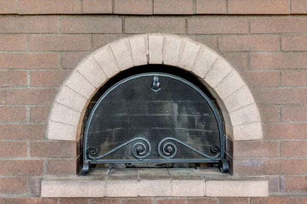 Bakstenen open haard met een tralie — Stockfoto