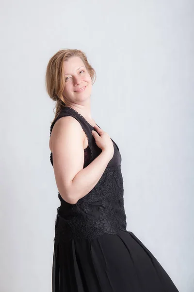Glimlachende vrouw in zwarte jurk — Stockfoto