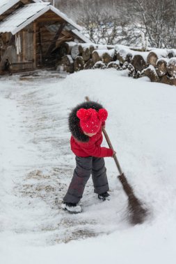 Kışın bir süpürge ile küçük kız