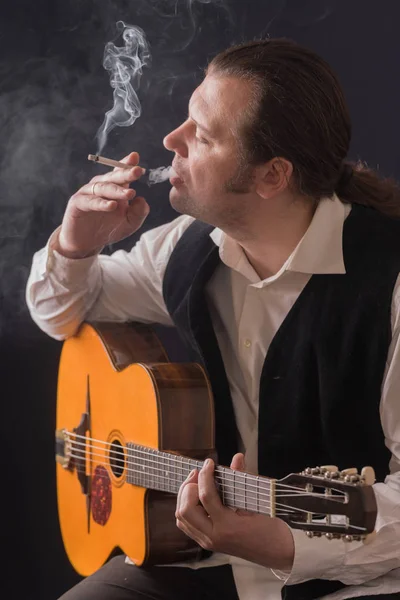 Der Musiker raucht eine Zigarette — Stockfoto