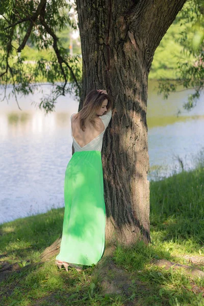 Menina esbelta à beira da árvore — Fotografia de Stock