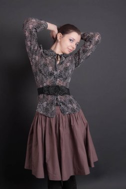 Bluz ve etek giymiş ince bir kız.