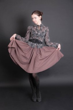 Bluz ve etek giymiş ince bir kız.