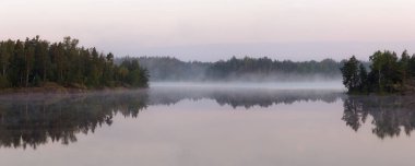 Bir orman gölü üzerinde sabah manzarası