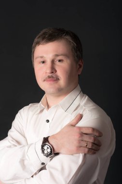 Beyaz gömlekli özgüvenli bir adamın stüdyo portresi.