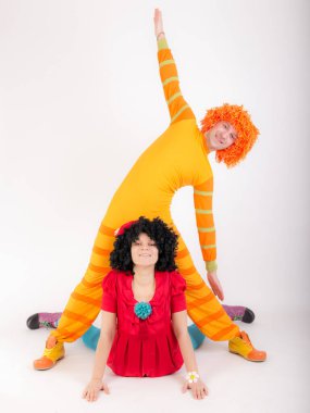 Yoga yapan palyaço kostümlü bir çiftin stüdyo portresi.