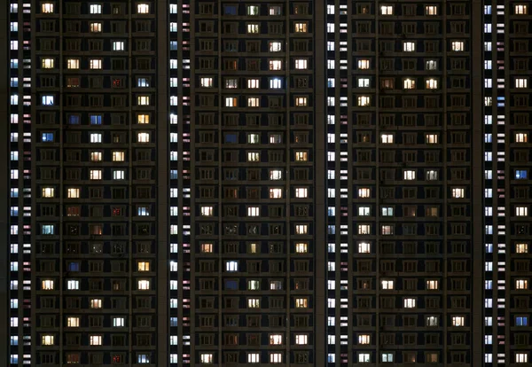 Ventanas de un edificio de apartamentos brillan en la oscuridad — Foto de Stock