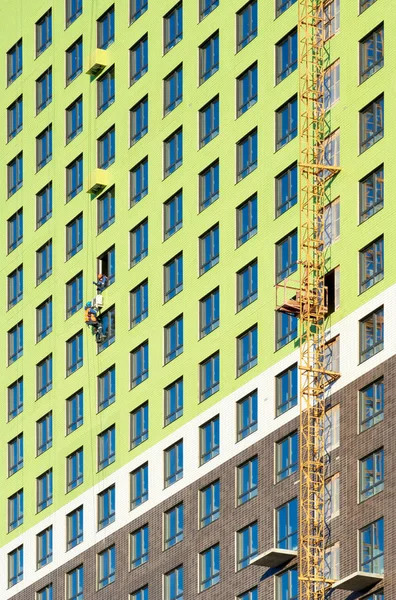 Trabajadores instalan acondicionadores de aire en la pared de una nueva construcción re — Foto de Stock