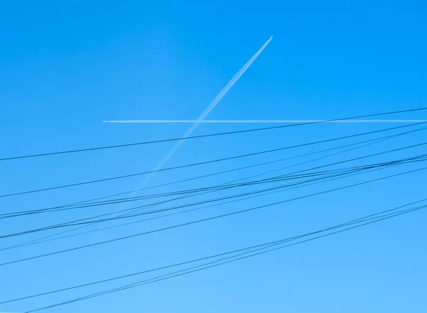 Vliegtuig paden gekruist in de hemel als draden — Stockfoto