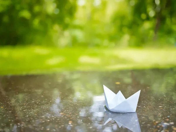 Paper boat floating in a puddle — Stock Photo, Image