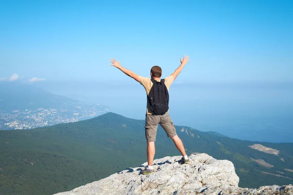 Homem com mochila no topo de uma montanha — Fotografia de Stock