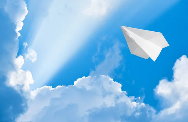 Avião de papel voando no céu entre as nuvens — Fotografia de Stock