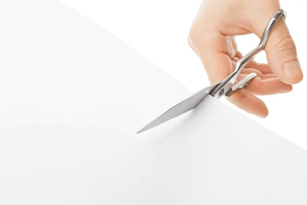 Hand with scissors cutting a white sheet of paper — Stock Photo, Image