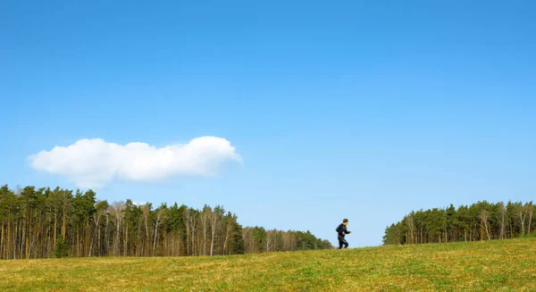 森と青空を背景に男を走らせる — ストック写真