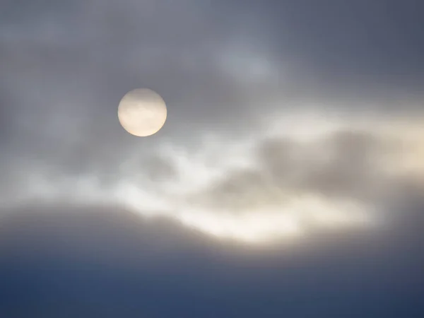 Δίσκος του ήλιου κρυφοκοιτάζει έξω από πίσω από τα σύννεφα — Φωτογραφία Αρχείου