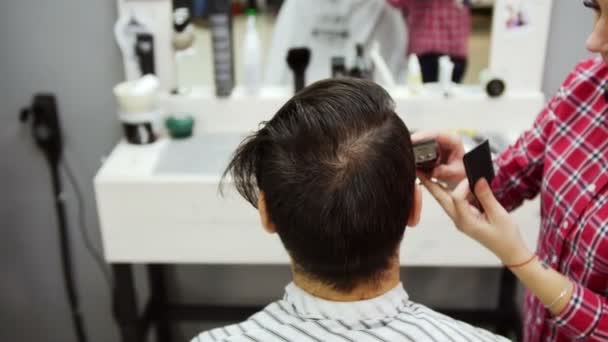 Barber coupe les cheveux du client avec des ciseaux — Video