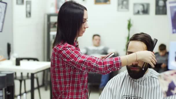 Peluquero corta el cabello del cliente con tijeras — Vídeo de stock