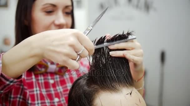 Barber coupe les cheveux du client avec des ciseaux. Mouvement lent — Video