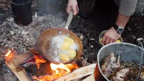 Aardappelen gebakken in een pan in buiten — Stockvideo