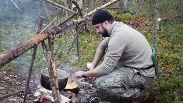 Κυνηγός άνδρας μαγειρεύει φαγητό από τη φωτιά — Αρχείο Βίντεο