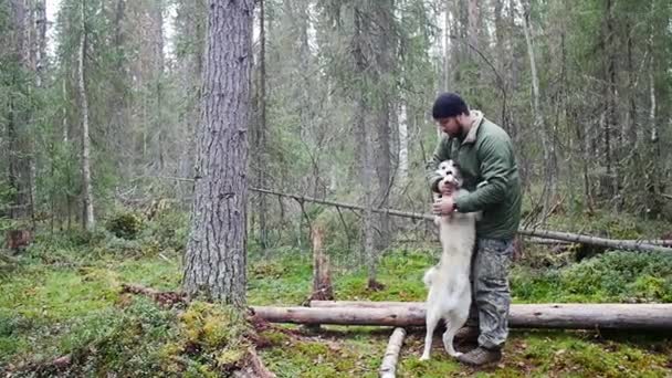 Man met zijn hond spelen in bos — Stockvideo