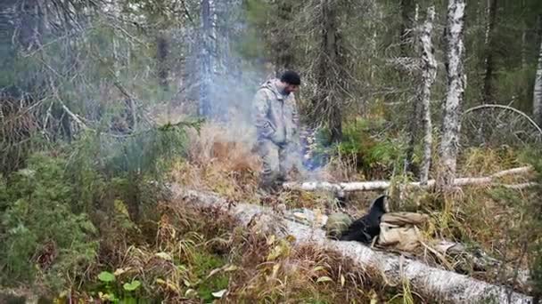 Hunter muž u ohně v lese — Stock video