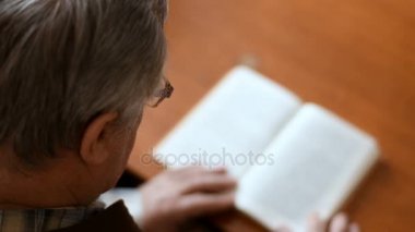 Evde kanepede oturan ihtiyar bir kitap okuma