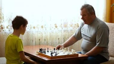 Satranç evinde dedesi ile oynayan çocuk