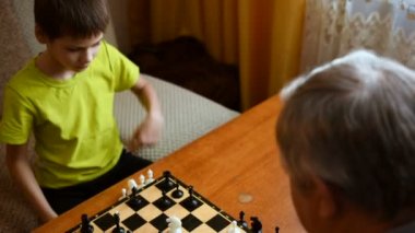 Satranç evinde dedesi ile oynayan çocuk