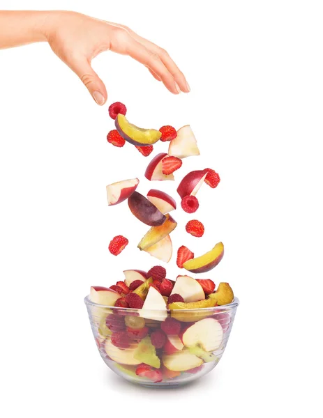 Кусочки фруктов падают в стеклянную чашу — стоковое фото
