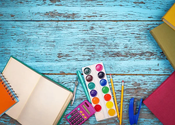 Boeken en briefpapier items zijn op een houten achtergrond — Stockfoto