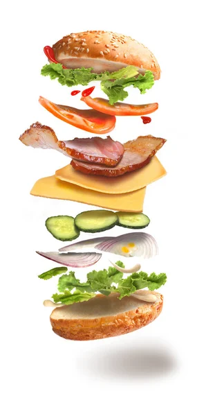 Hamburger with flying ingredients on white background — Stock Photo, Image