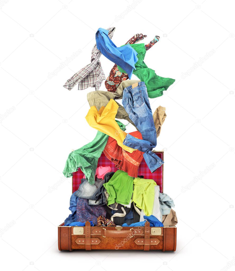 Clothes fall into open suitcase isolated on a white background