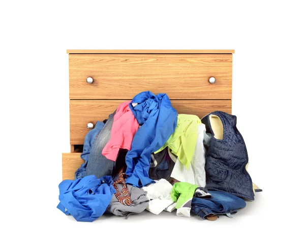 Uma pilha de roupas caindo da cômoda isolado em b branco — Fotografia de Stock