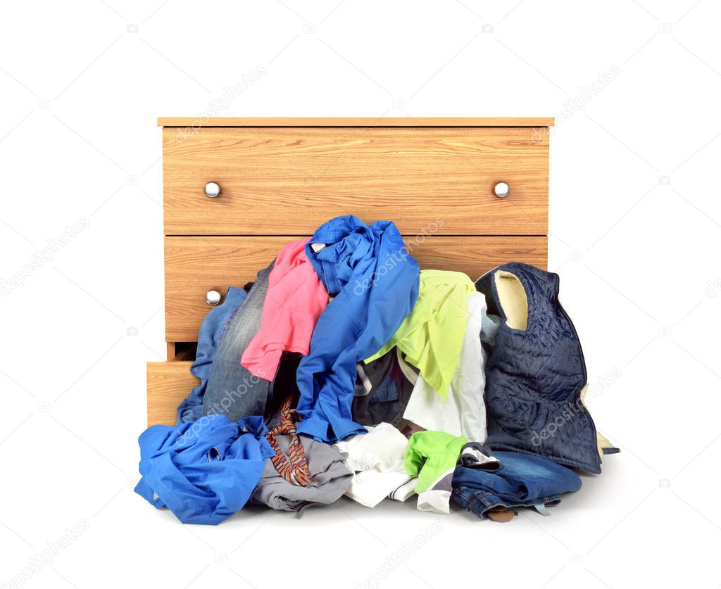 A pile of clothes falling out of the dresser isolated on white b