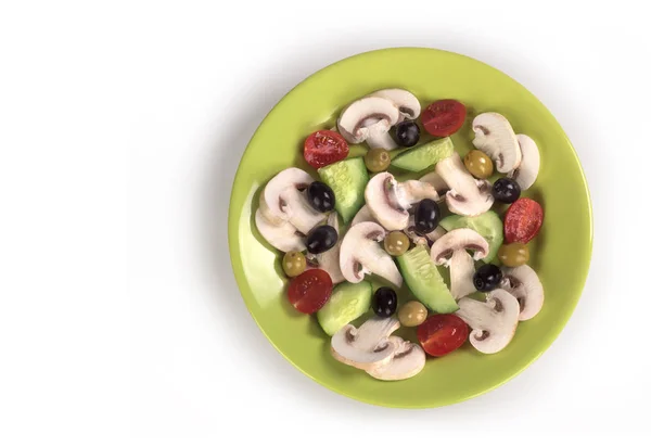 Salat in einem hellgrünen Teller auf weißem Hintergrund — Stockfoto