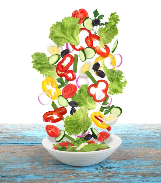 Fliegender Salat mit Teller auf Holztisch — Stockfoto