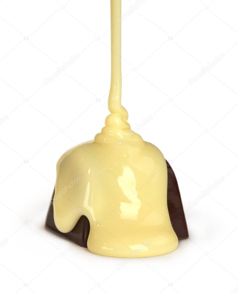 sweet milk pouring on chocolate candy isolated