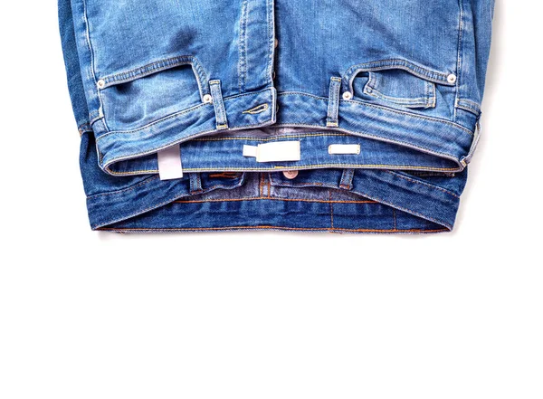 Paar Jeans. Weißer Hintergrund, auf dem zwei Paar Jeans liegen. — Stockfoto