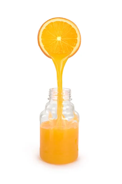 Suco de laranja derramando de fatia de laranja em garrafa isolada — Fotografia de Stock