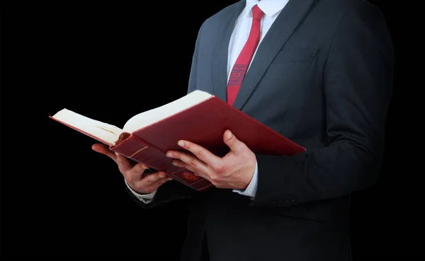 Siyah bir arka plan üzerine açık bir kitap tutan takım elbiseli adam — Stok fotoğraf
