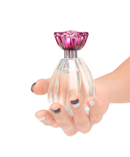 Beautiful female hand holding the bottle of perfume isolated on 