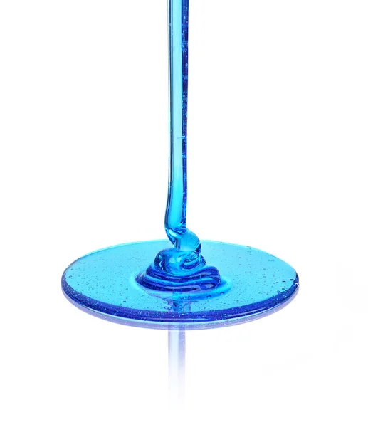 Líquido azul que vierte sobre la superficie de vidrio — Foto de Stock