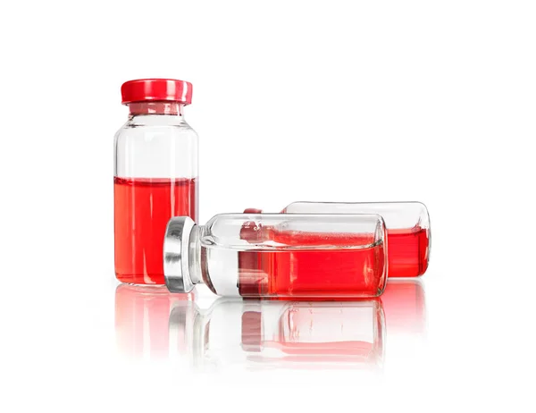 Glass jars with a red and transparent liquid, isolated on a white background — Stock Photo, Image